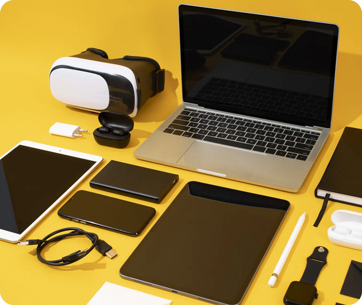 Technology products arranged around a laptop